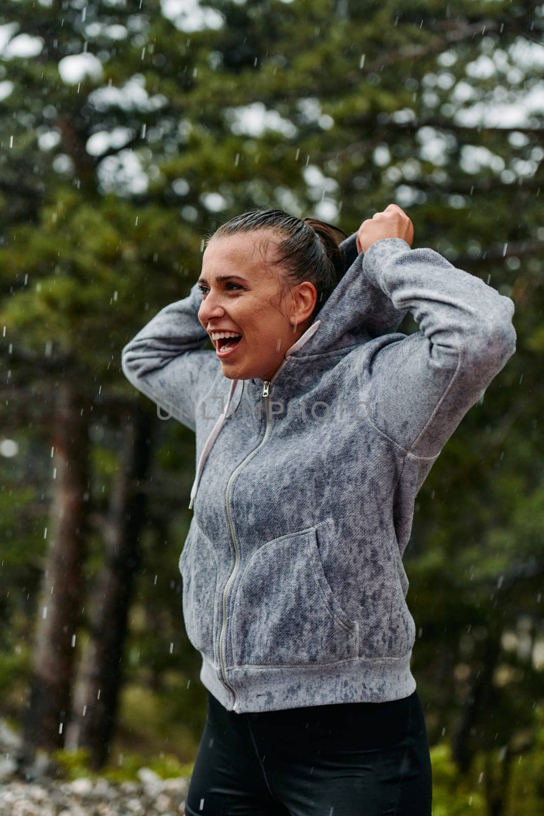 A stunning woman savors the tranquility of a rainy day after a rigorous run, finding solace and rejuvenation in the soothing rhythm of the falling rain.