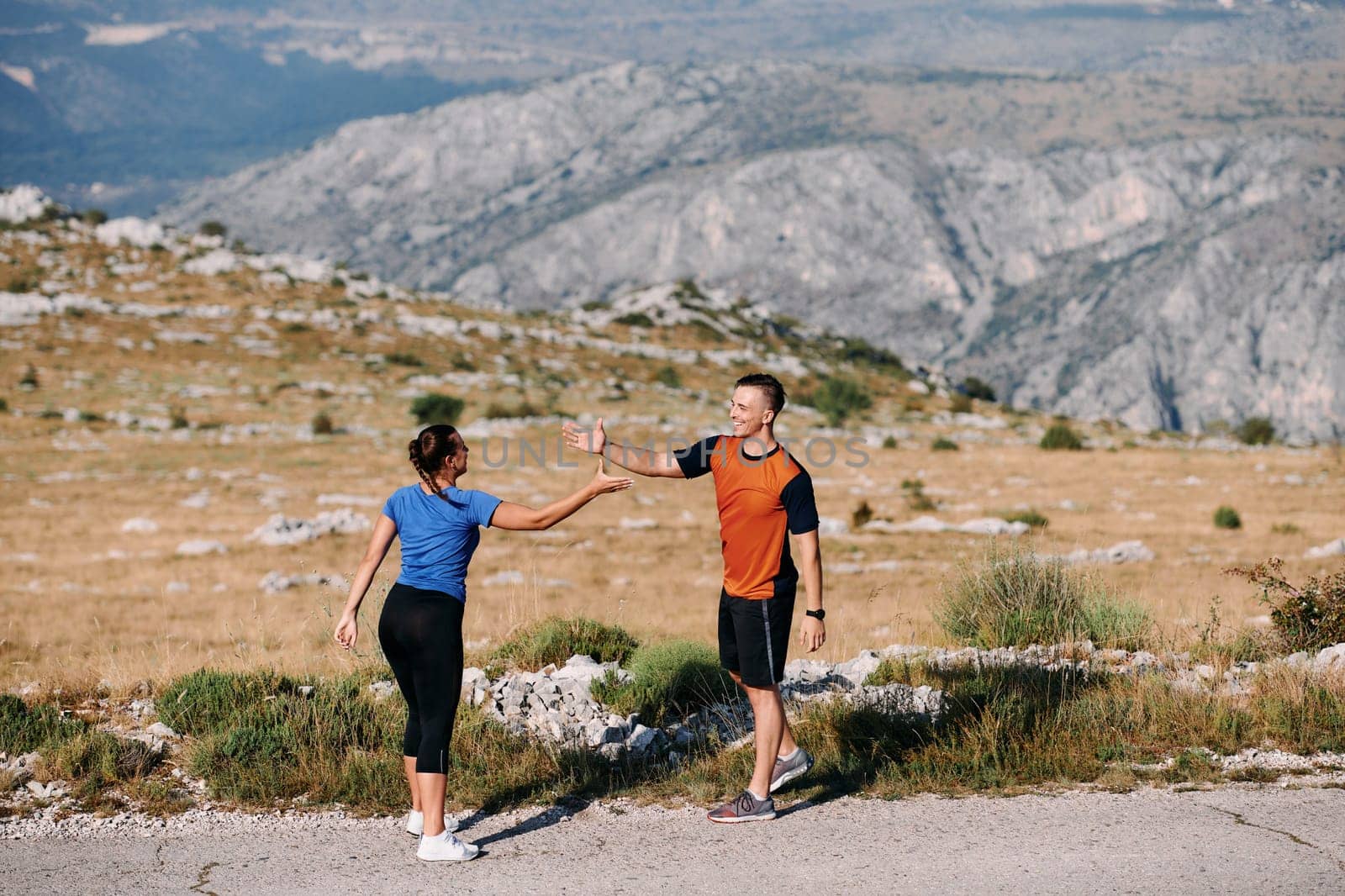 A jubilant couple celebrates their triumphant finish after a challenging morning run, exuding happiness and unity amidst the refreshing outdoor scenery.