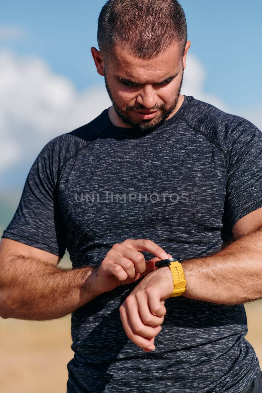 An athletic man checks the results of his run on a smartwatch, leveraging technology to monitor his performance and progress in his fitness journey