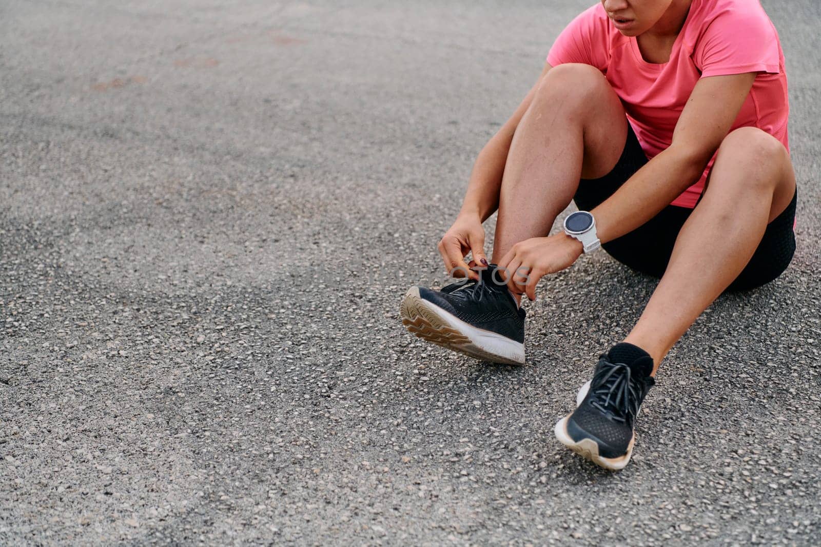 An athletic woman prepares herself for a morning run, embodying dedication and determination in her fitness routine