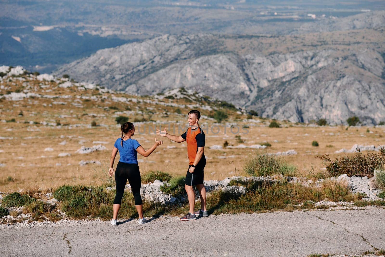 A jubilant couple celebrates their triumphant finish after a challenging morning run, exuding happiness and unity amidst the refreshing outdoor scenery.