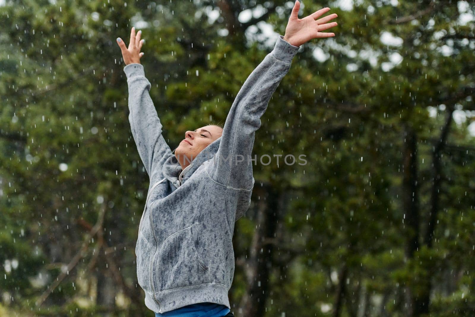 A woman, drenched but delighted, enjoys the invigorating rain after a fulfilling run, embodying a perfect blend of fitness and freedom.