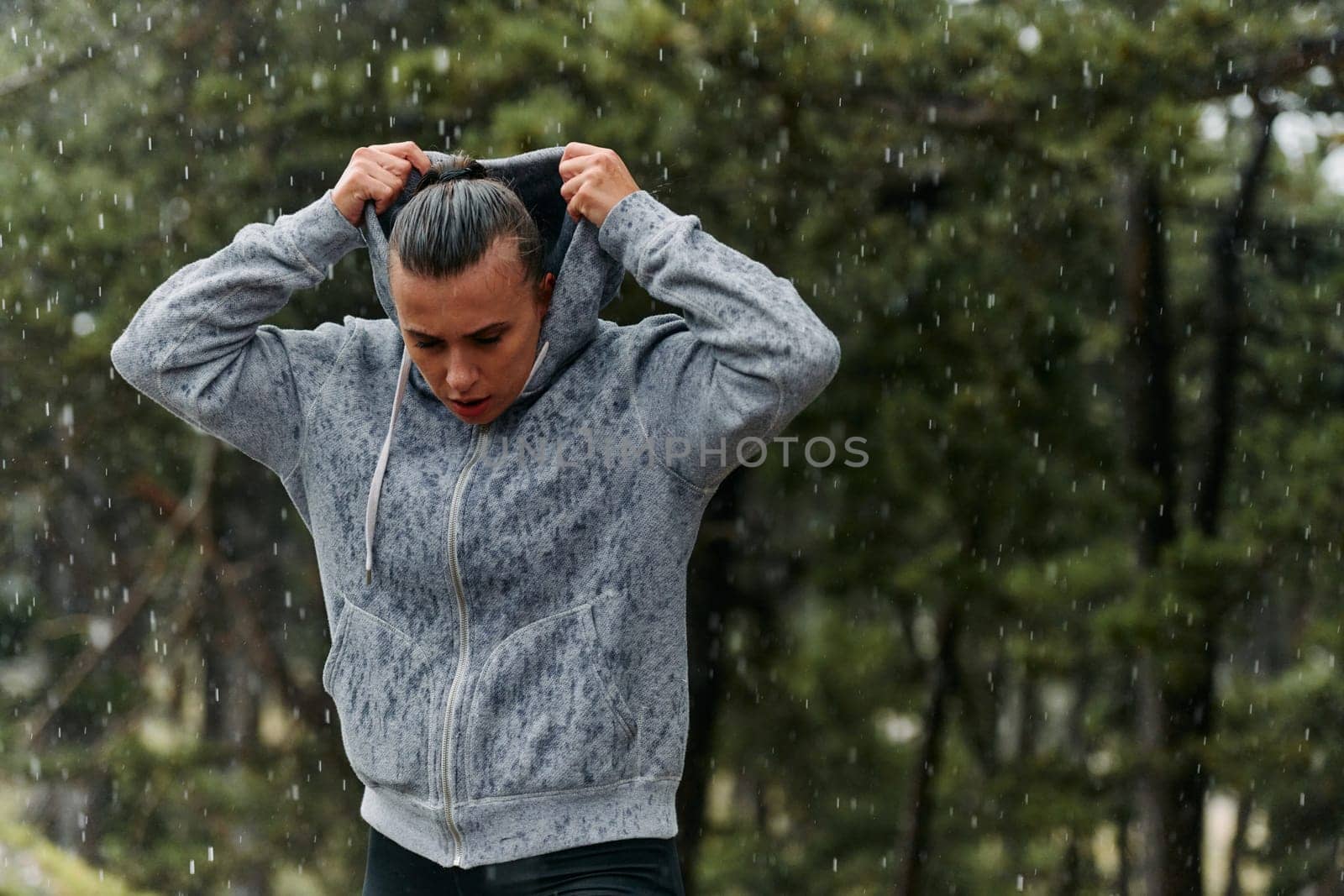 A stunning woman savors the tranquility of a rainy day after a rigorous run, finding solace and rejuvenation in the soothing rhythm of the falling rain.