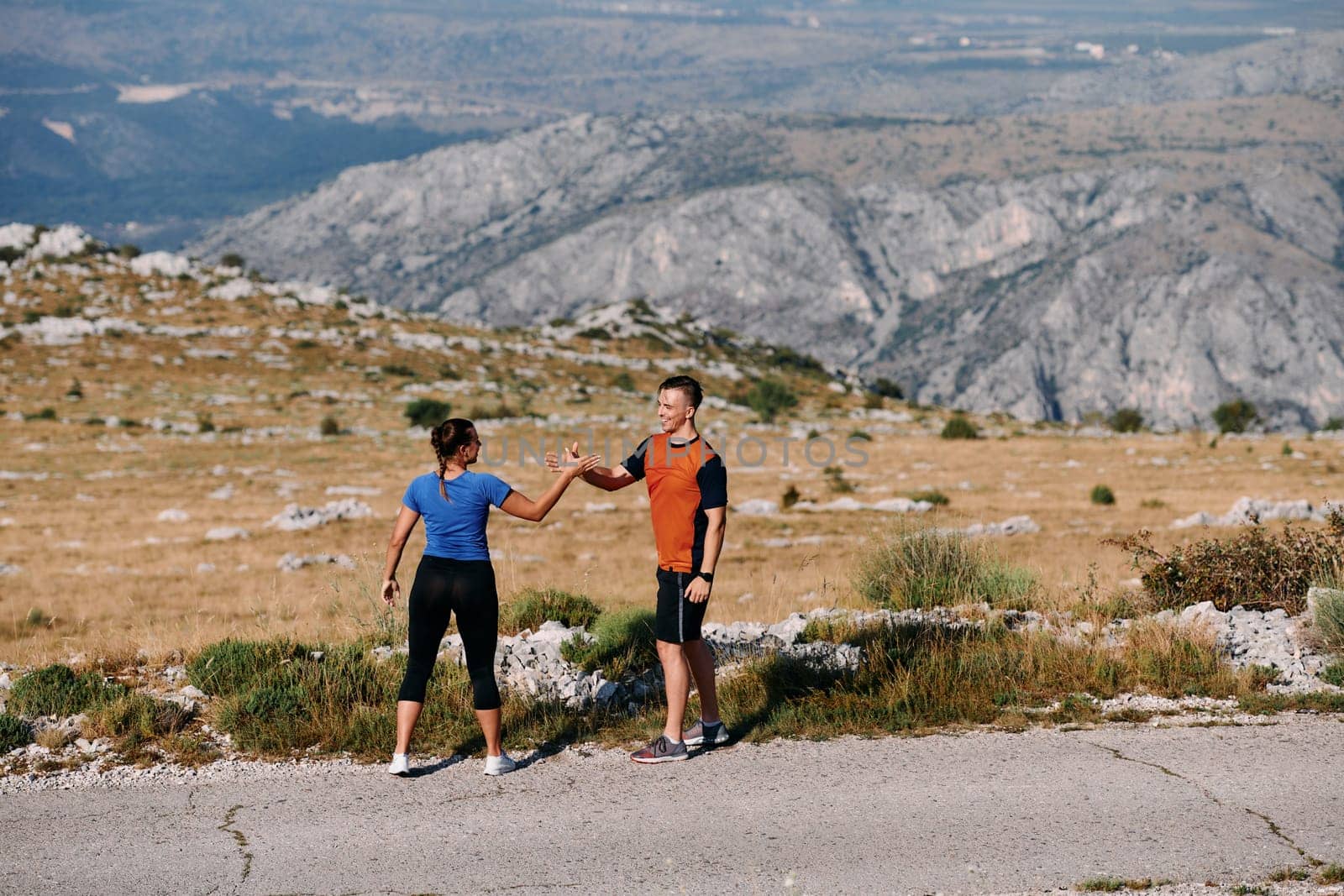 A jubilant couple celebrates their triumphant finish after a challenging morning run, exuding happiness and unity amidst the refreshing outdoor scenery.