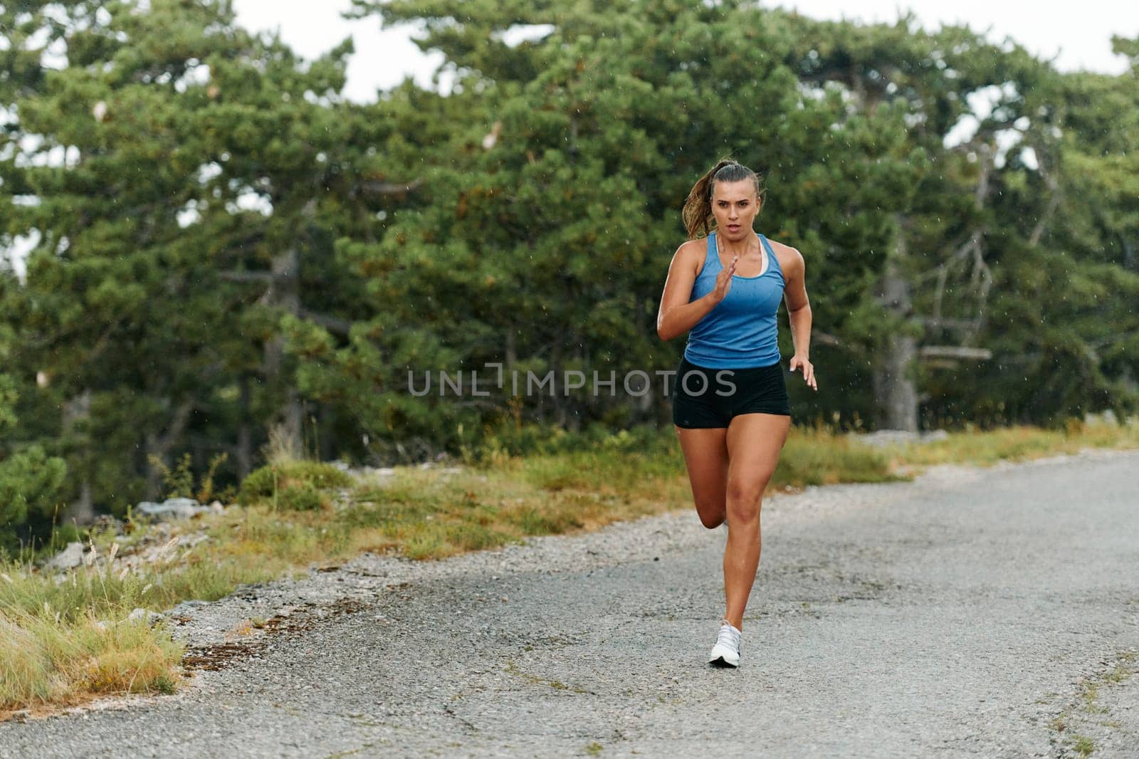 Rain or shine, a dedicated woman powers through her training run, her eyes set on the finish line.