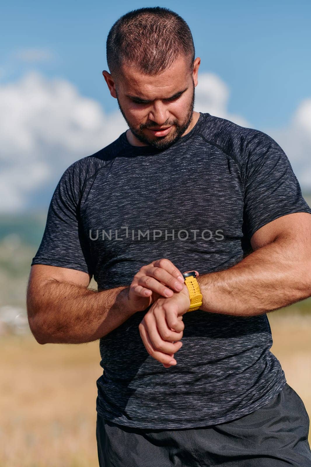 An athletic man checks the results of his run on a smartwatch, leveraging technology to monitor his performance and progress in his fitness journey