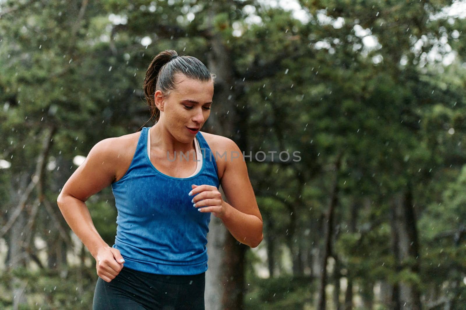 Rain or shine, a dedicated woman powers through her training run, her eyes set on the finish line.