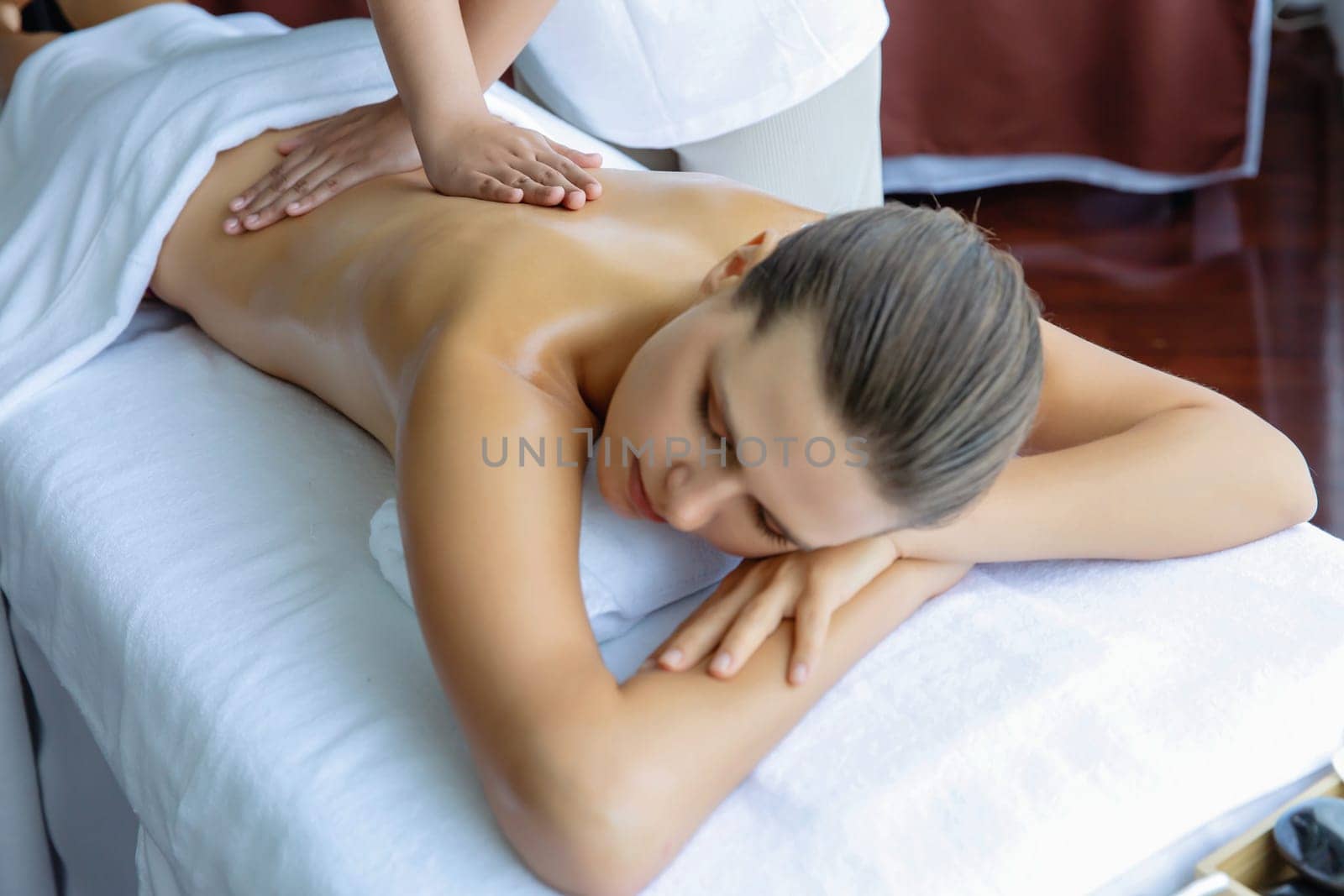 Caucasian woman customer enjoying relaxing anti-stress massage. Quiescent by biancoblue