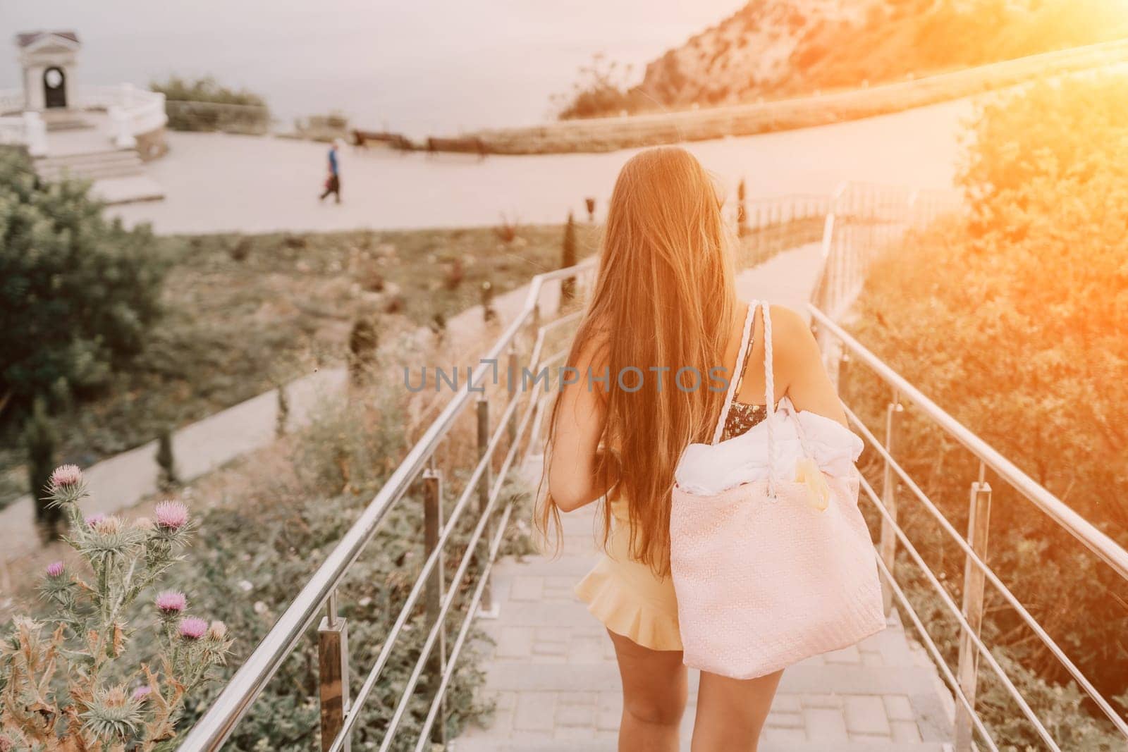 Woman travel sea. Happy tourist enjoy taking picture outdoors for memories. Woman traveler looks at the edge of the cliff on the sea bay of mountains, sharing travel adventure journey by panophotograph