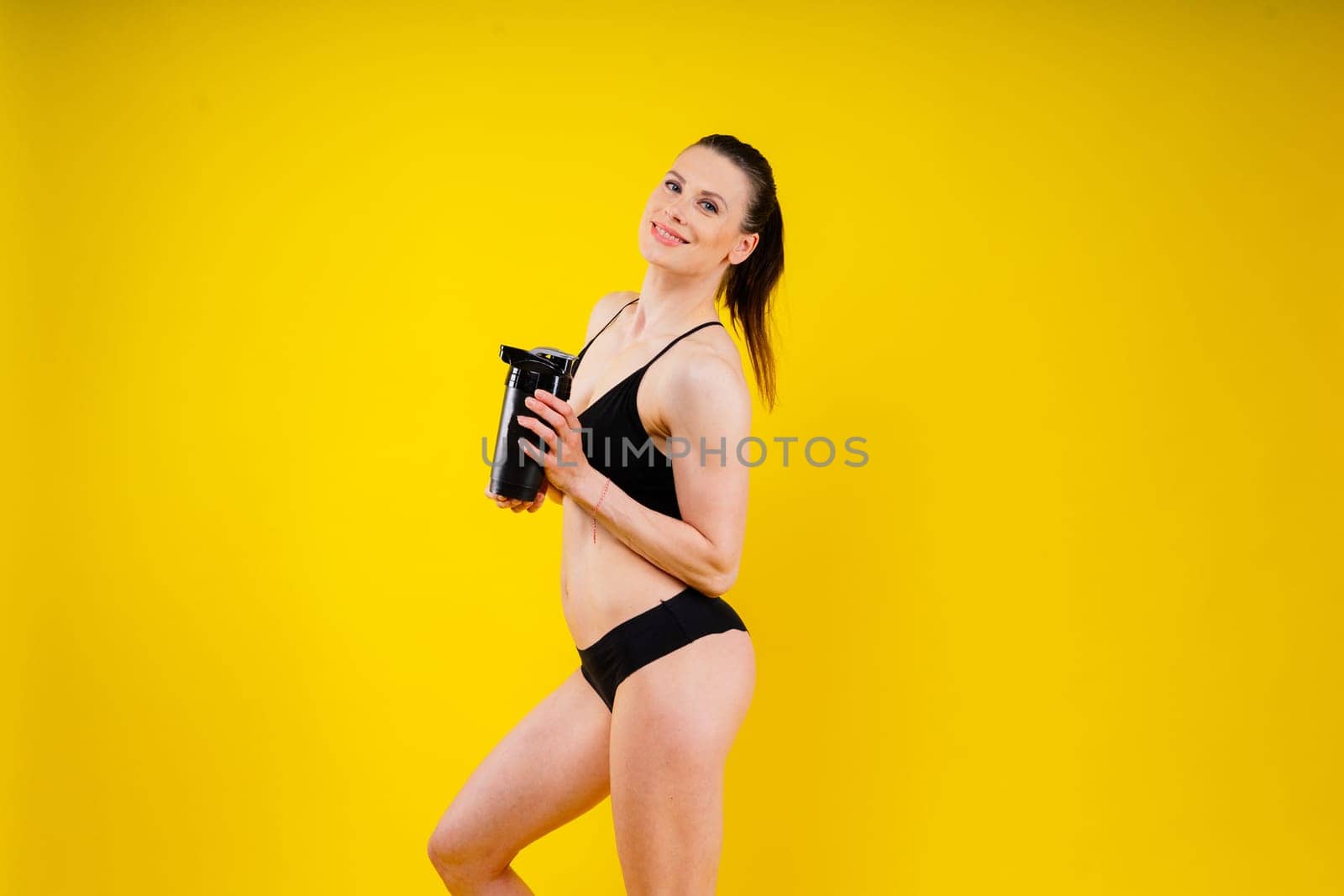 Sporty female drinking water after workout. Photo of fitness woman. Healthy lifestyle by Zelenin