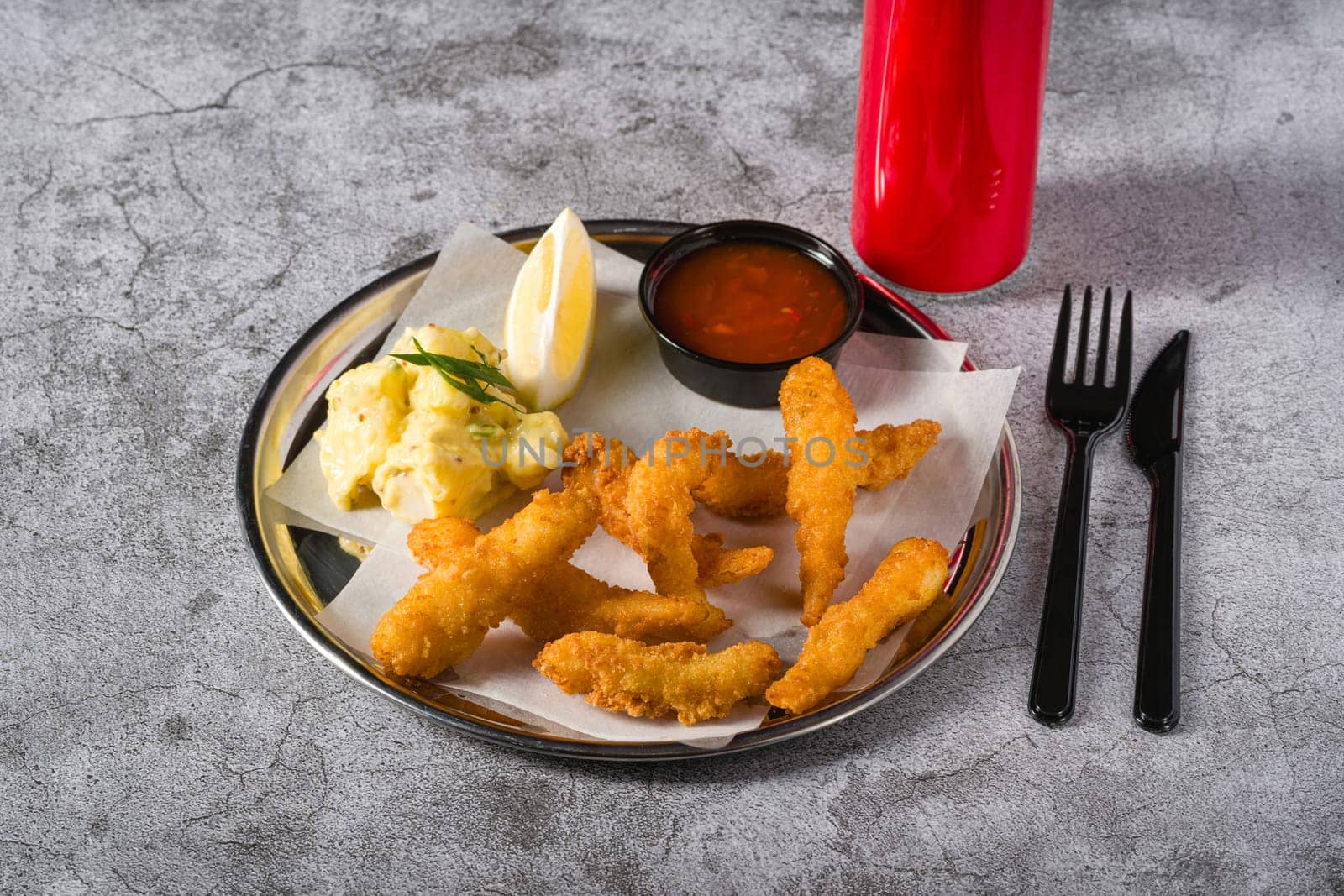 Deep fried shrimp tempura with potato salad on a metal plate