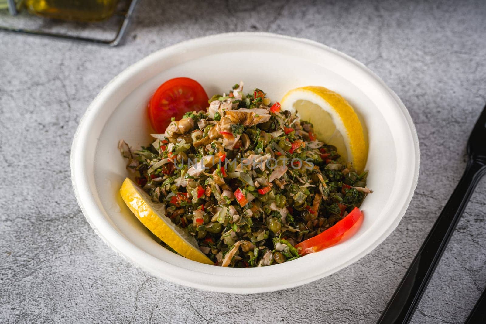 Healthy salad with capers, quinoa and walnuts on stone table by Sonat