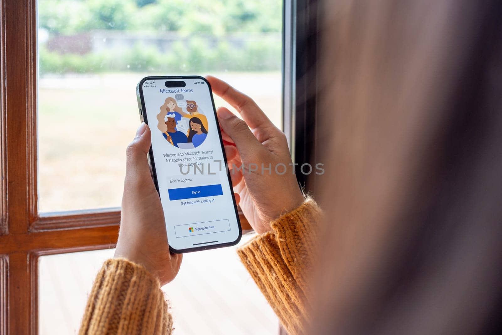 30 April 2023 Chiangmai, Thailand : Woman holding smartphone mobile show Microsoft Teams social platform, group chat platform app.