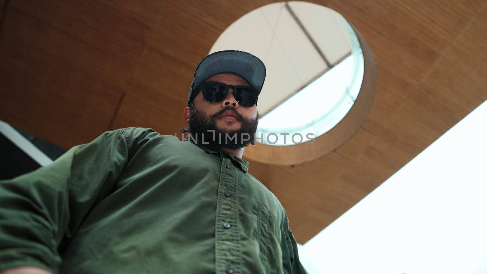 Motion shot of asian handsome hipster pose in hip hop style while looking at camera. Low angle image of professional street dancer dance in freestyle movement at mall. Outdoor sport 2024. Endeavor.