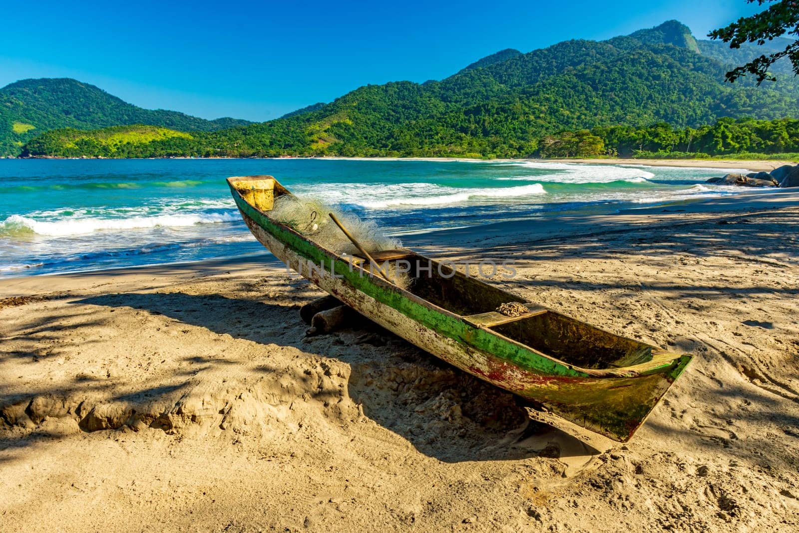 Primitive wooden fishing canoe on the sands of Castelhanos beach in Ilhabela