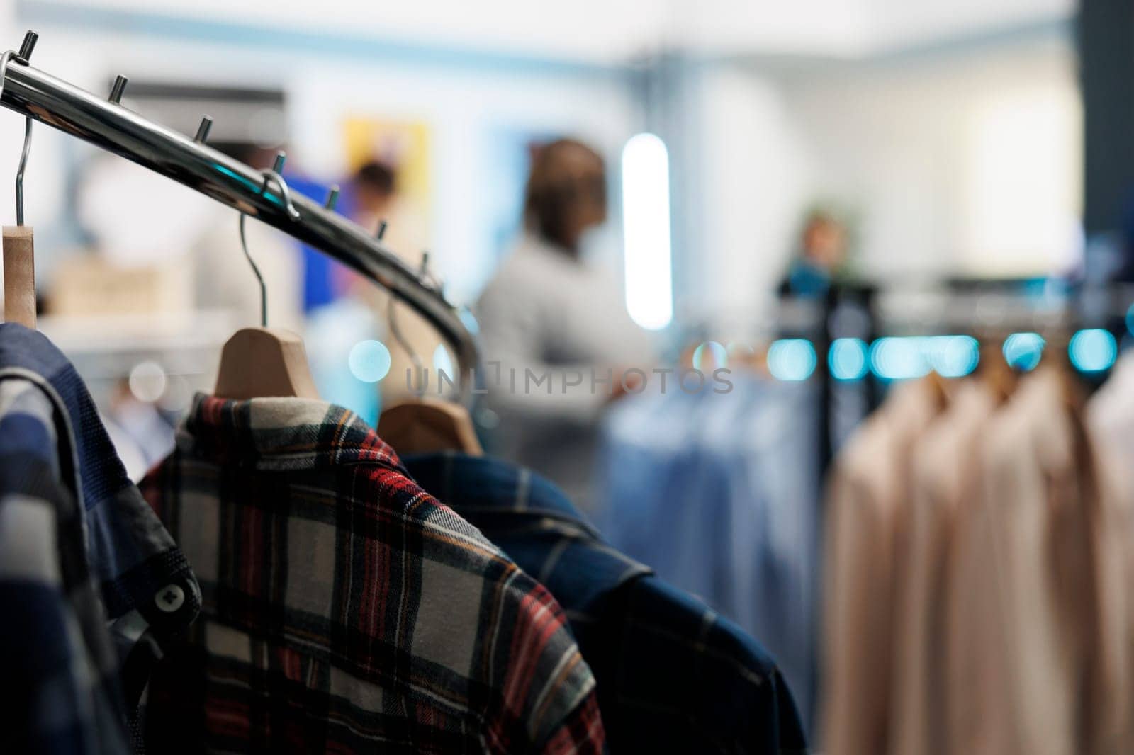 Shirts hanging on rack in clothing store by DCStudio