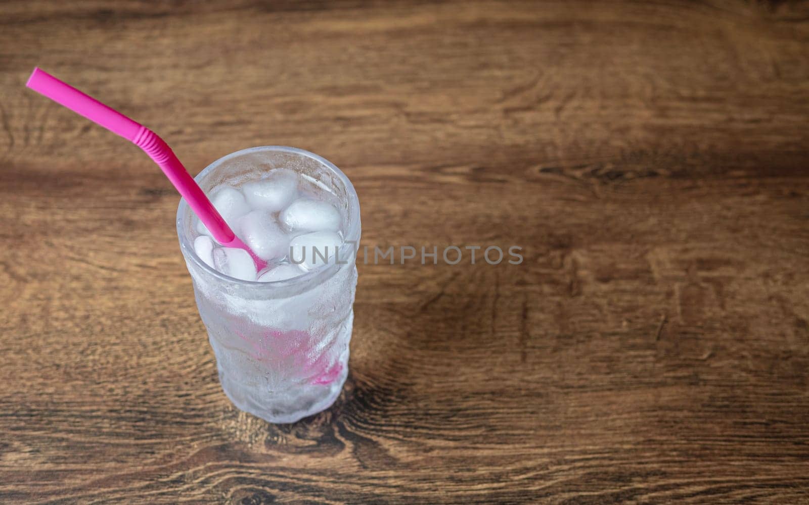 cold water drink with pink drinking straw. copy space