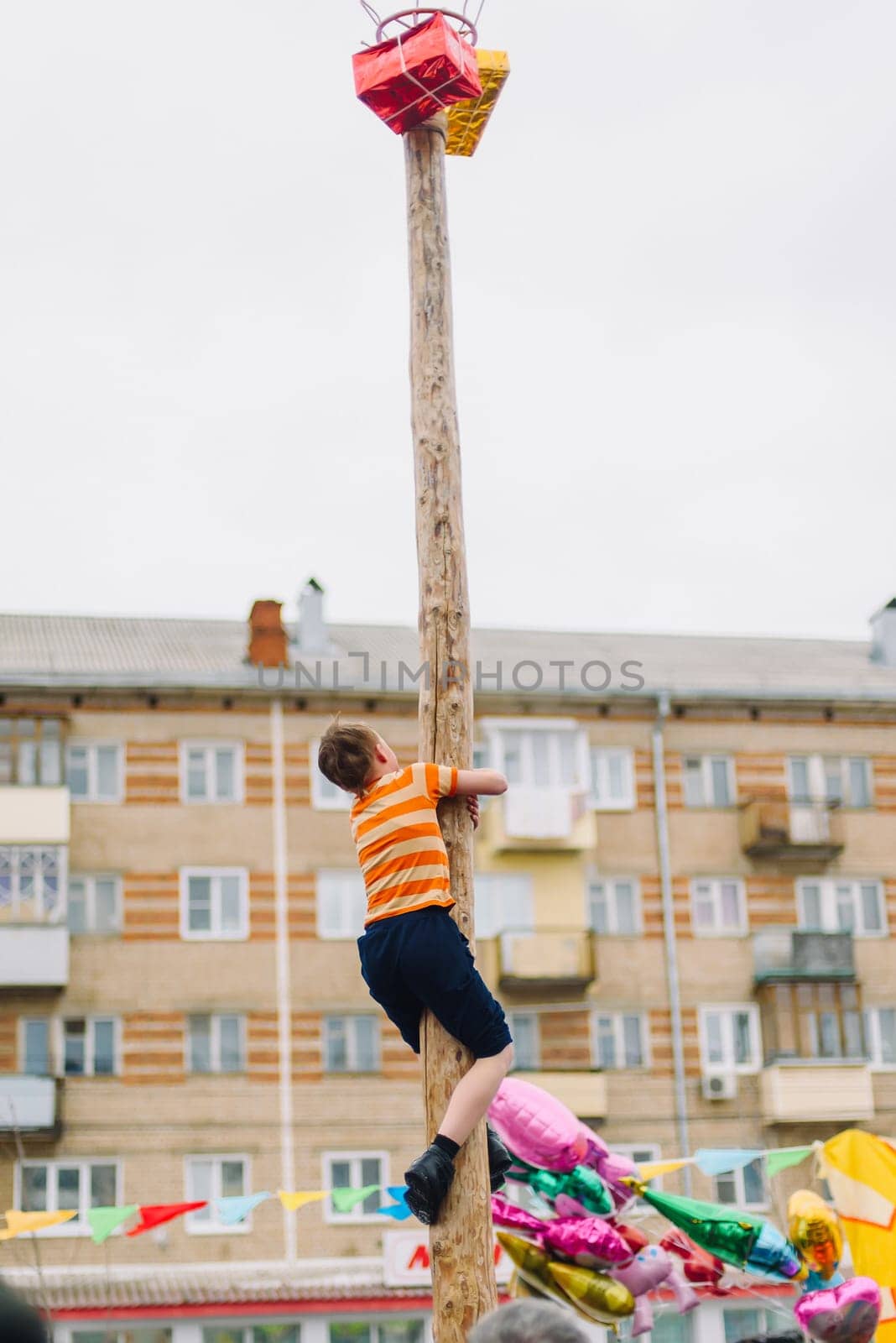 VICHUGA, RUSSIA - MARCH 12, 2016: Celebration of the Russian Slavic holiday Maslenitsa. Traditional competitions on climbing the pole for gifts