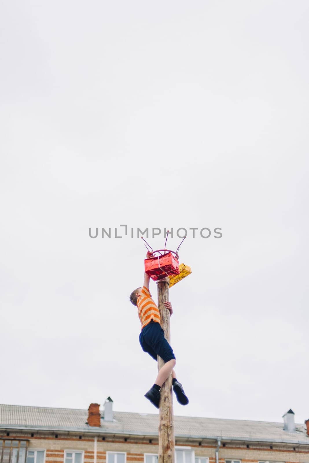 VICHUGA, RUSSIA - MARCH 12, 2016: Celebration of the Russian Slavic holiday Maslenitsa. Traditional competitions on climbing the pole for gifts
