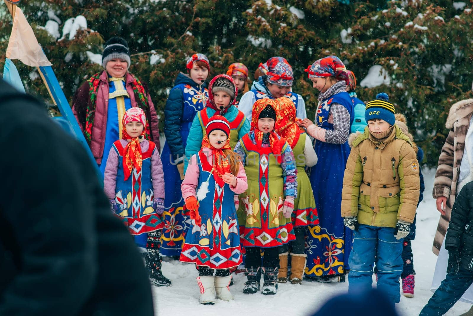VICHUGA, RUSSIA - FEBRUARY 17, 2018: crowd of girls on stage sing songs in traditional Slavic costumes at the winter Russian celebration of the Maslenitsa holiday