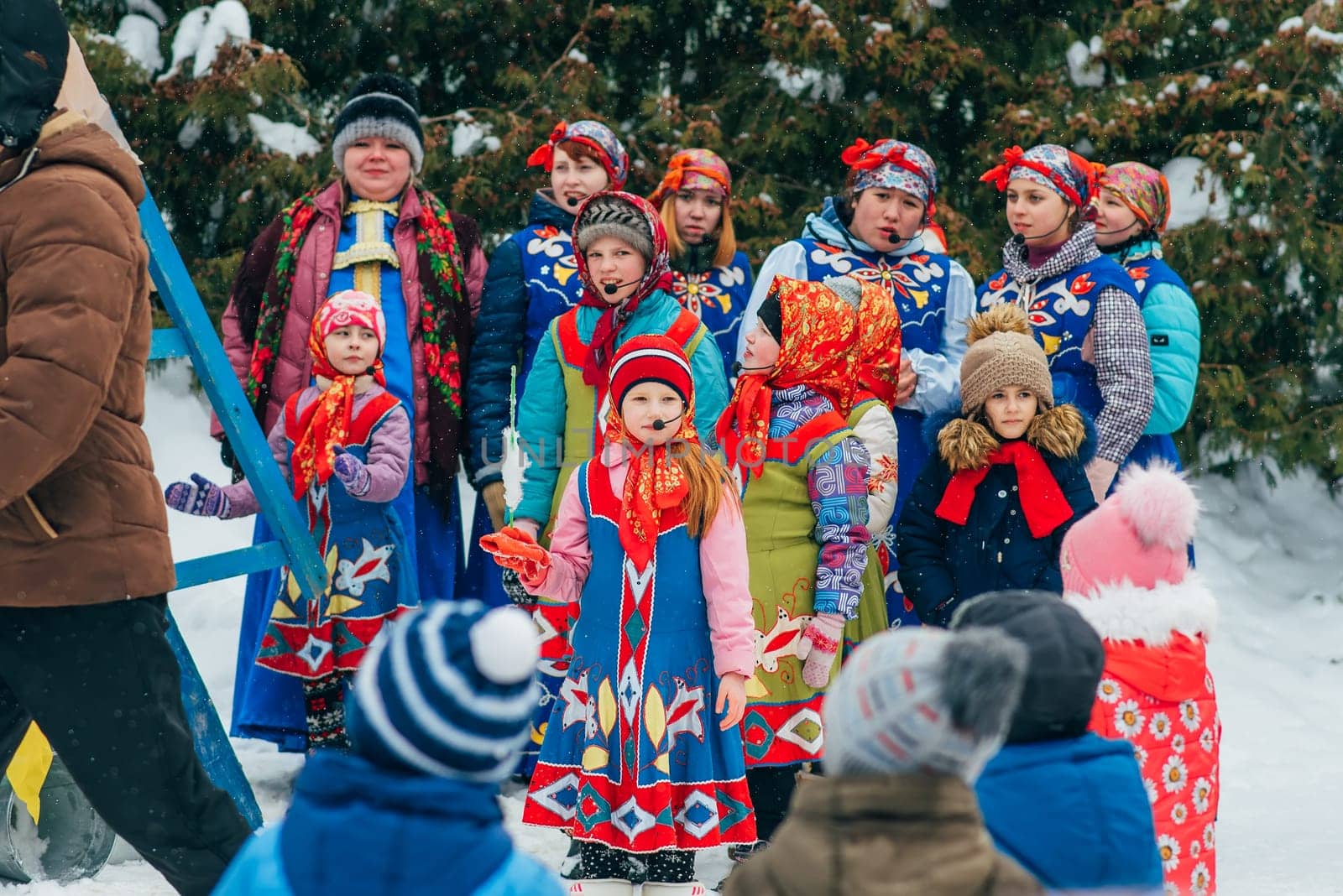 VICHUGA, RUSSIA - FEBRUARY 17, 2018: crowd of girls on stage sing songs in traditional Slavic costumes at the winter Russian celebration of the Maslenitsa holiday