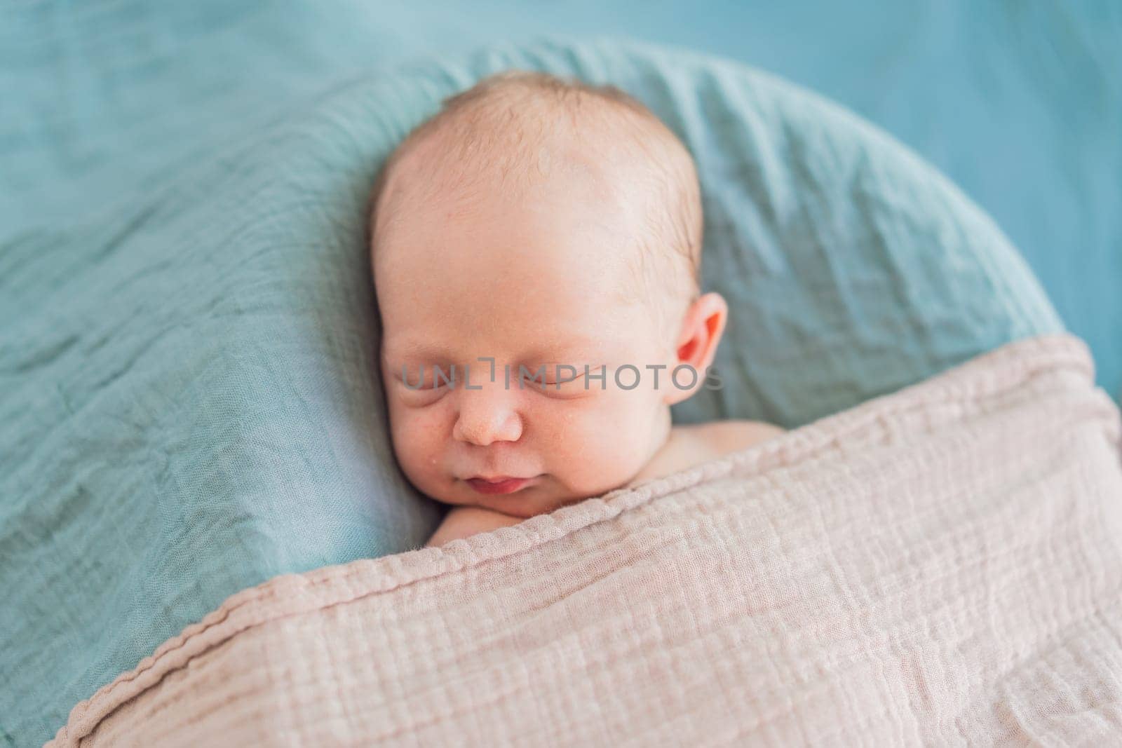 The baby is sleeping peacefully in his cozy nest. Newborn photo session captures the serene innocence and warmth of early moments.