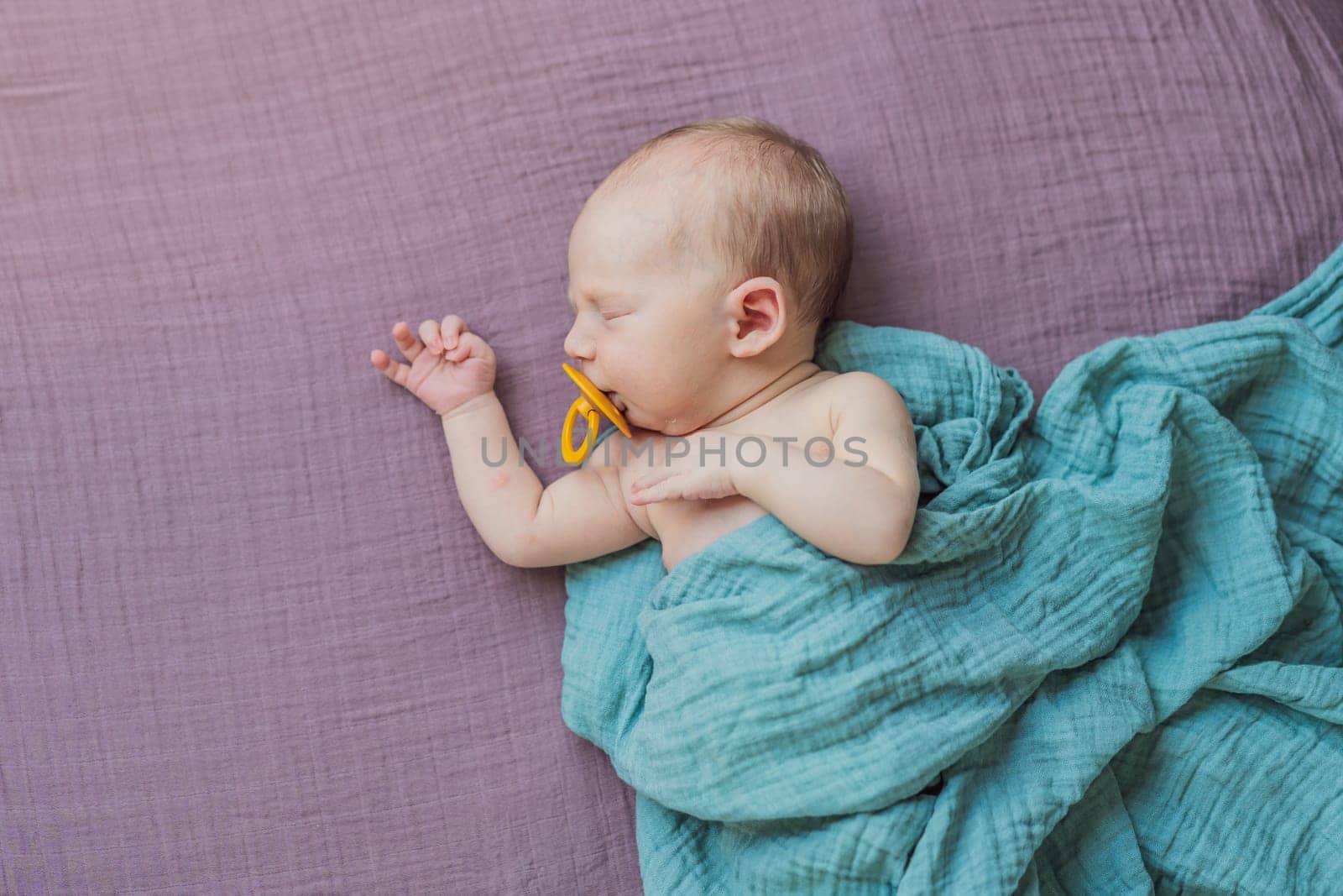 The baby is sleeping peacefully in his cozy nest. Newborn photo session captures the serene innocence and warmth of early moments.