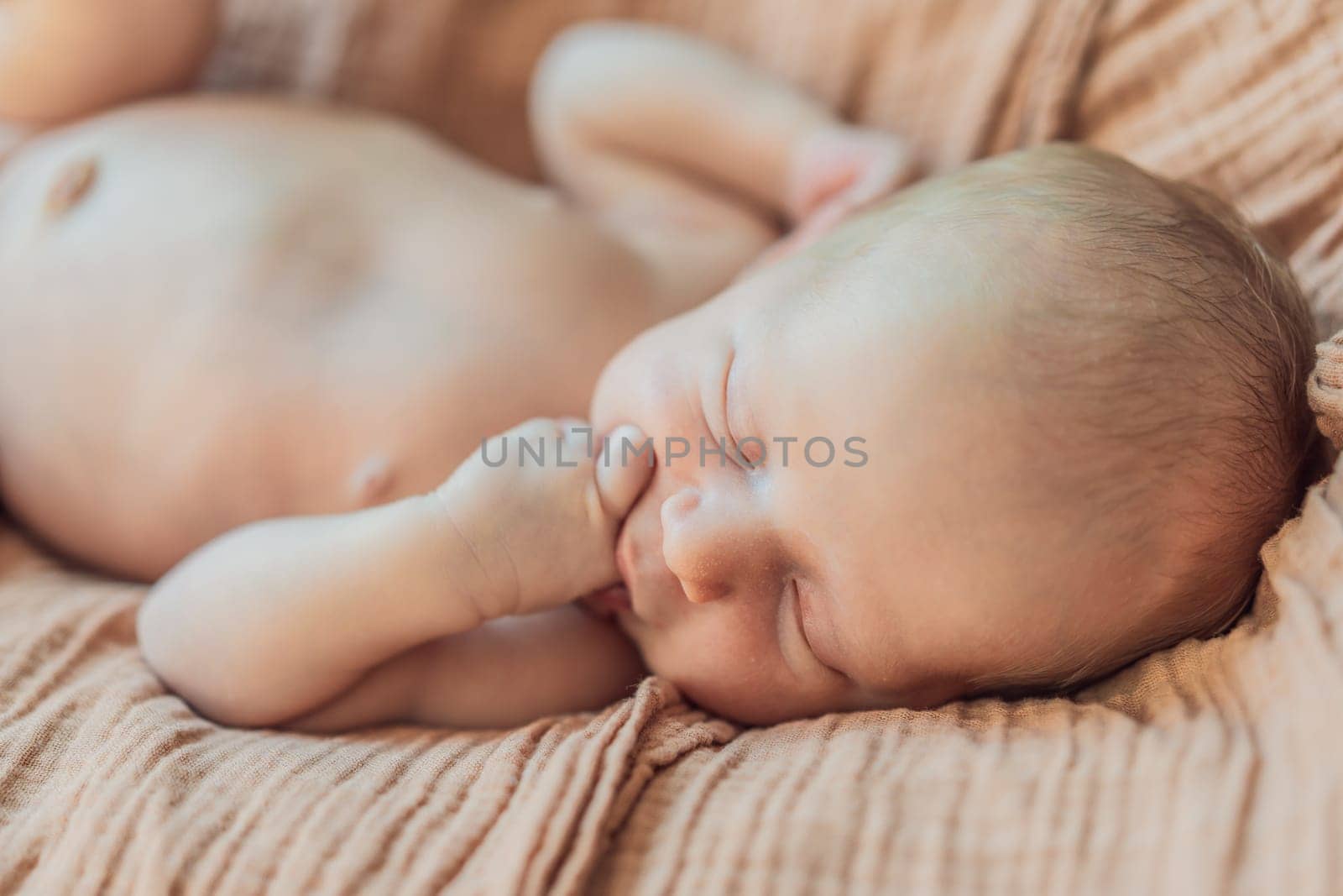 The baby is sleeping peacefully in his cozy nest. Newborn photo session captures the serene innocence and warmth of early moments.