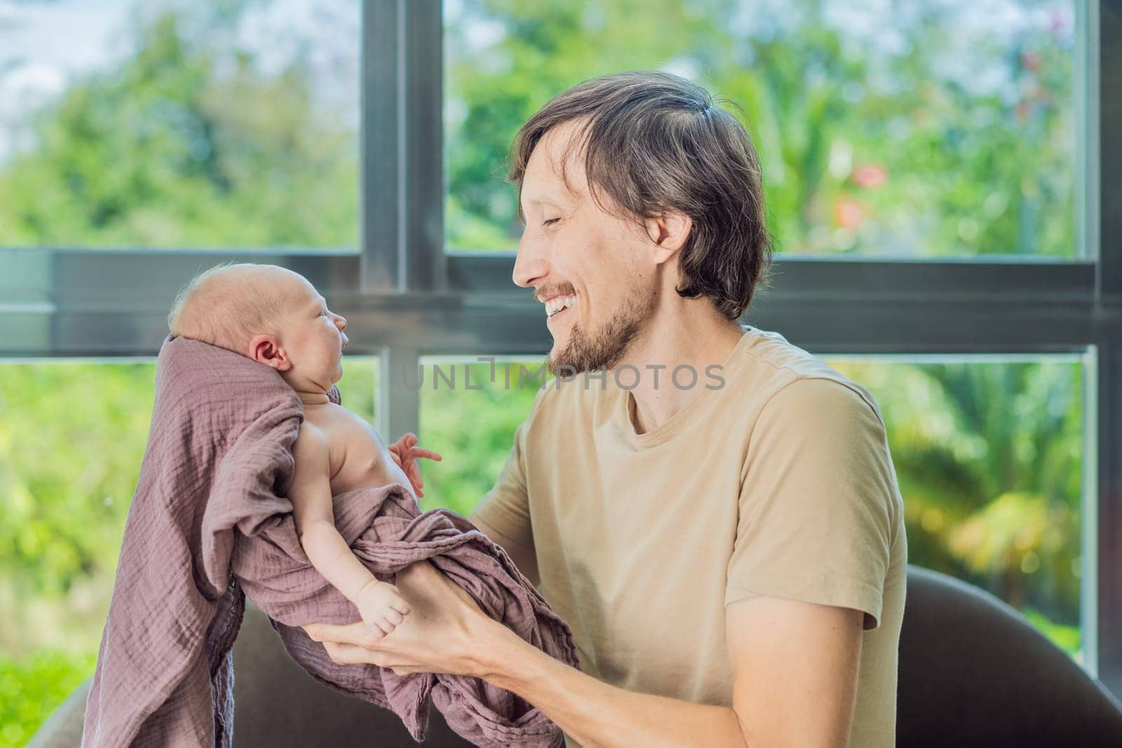 Dad and newborn at home. This tender moment captures the bond between father and child in a loving and comfortable family environment highlighting the joys of parenthood and the warmth of home.