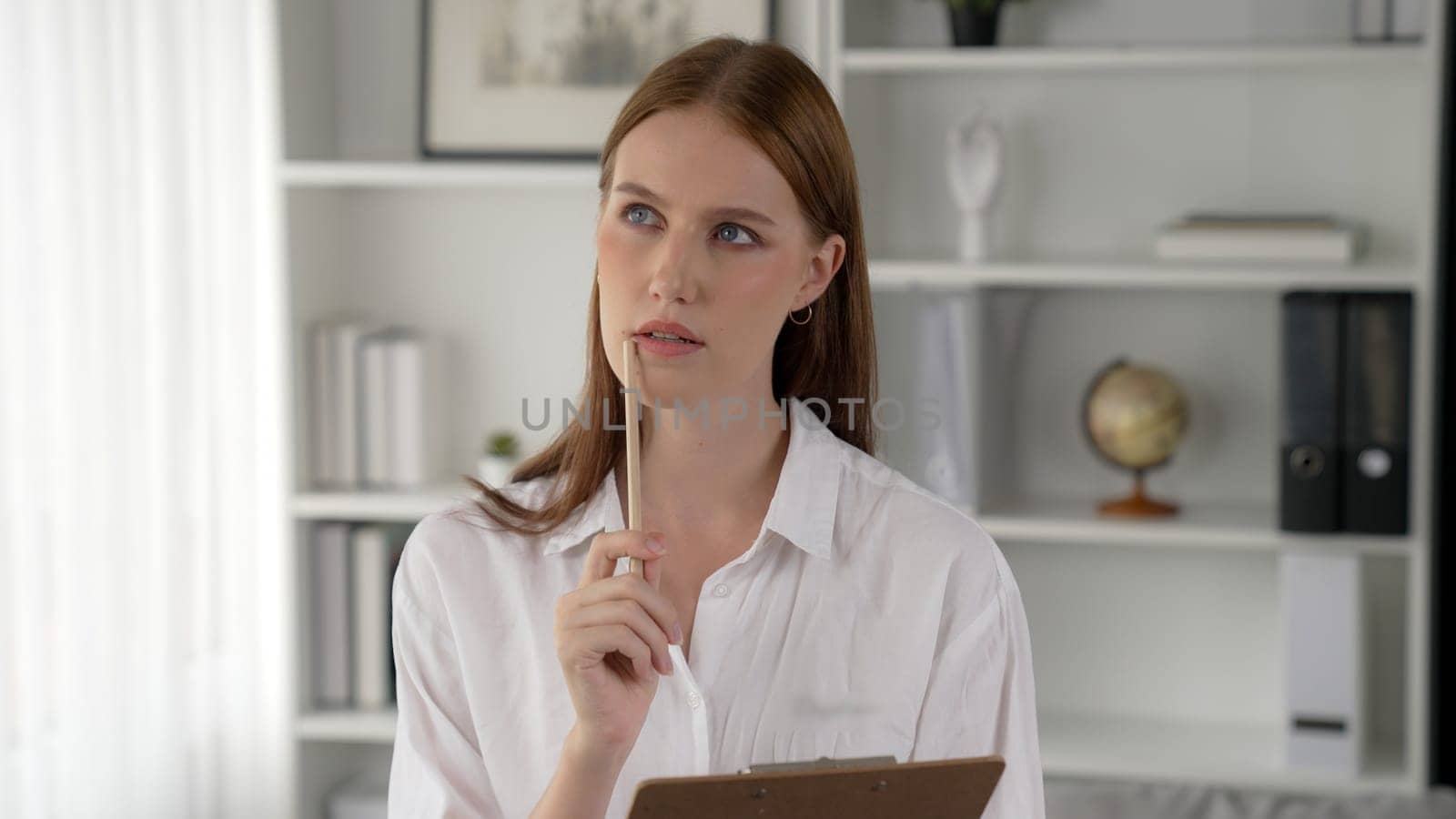 Thoughtful and pensive psychologist woman in clinic office professional portrait with smile and holding clipboard for patient to visit psychologist. The experienced and prim confident psychologist