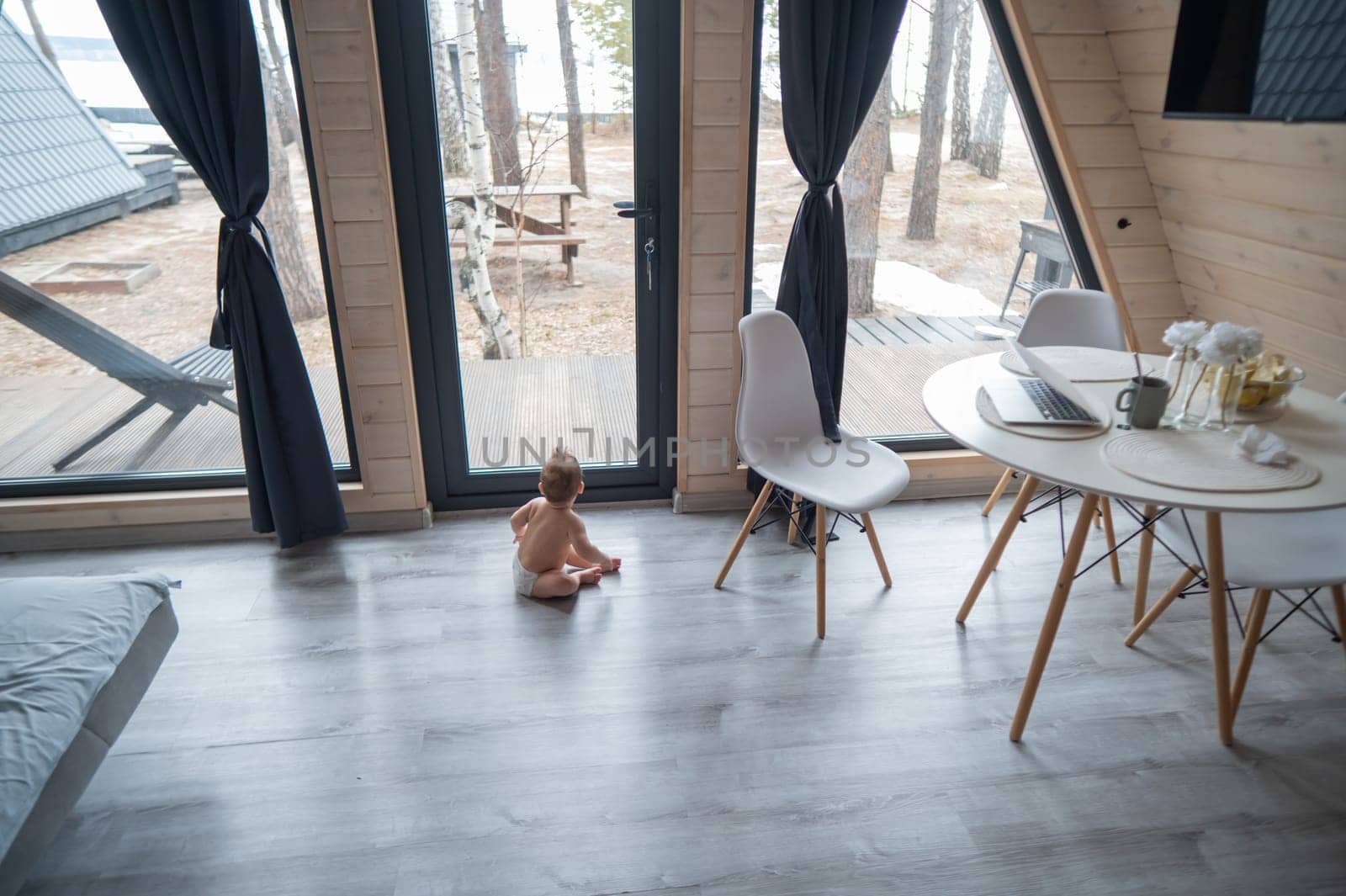 Little boy crawling on the floor by the patio window. by mrwed54