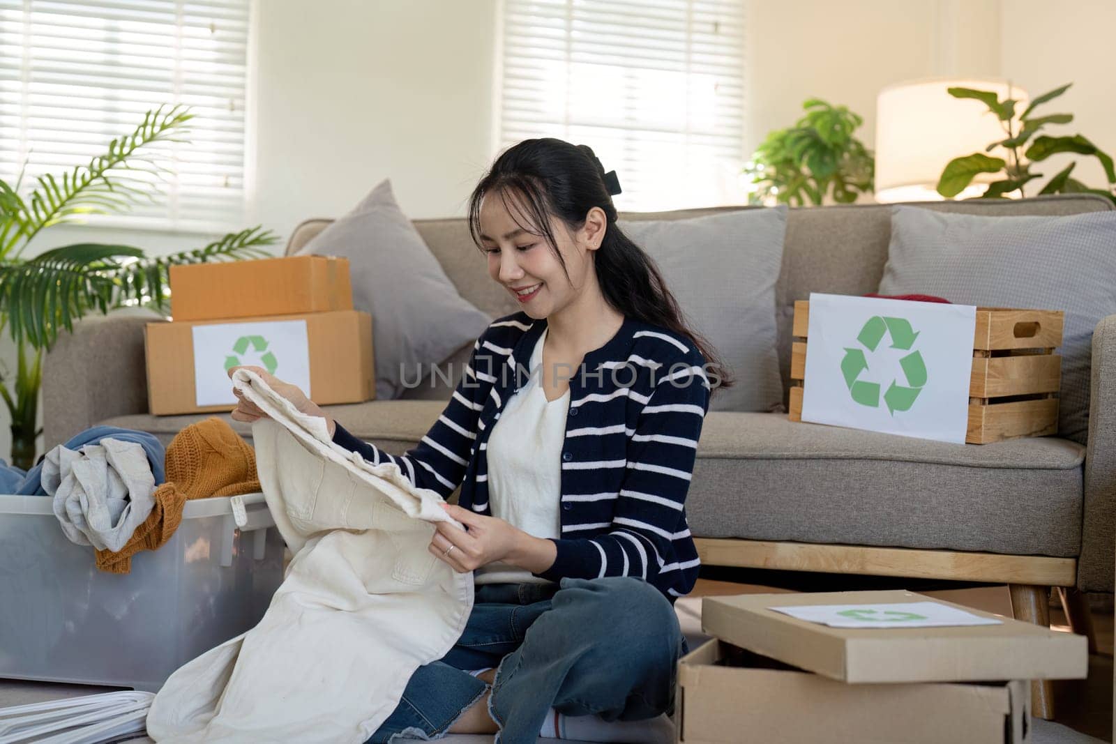 Young Woman volunteer to Recycle and Donation Clothes at Home, Promoting Sustainable Living and Environmental Responsibility by nateemee