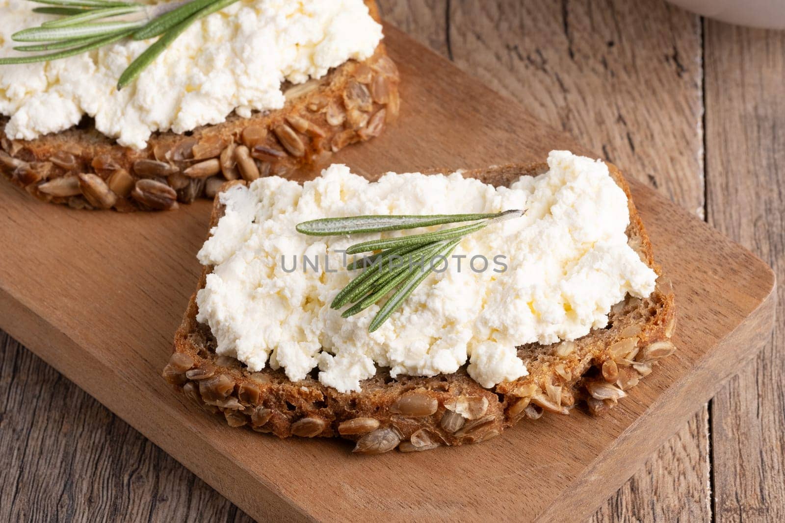 Home made rye bread on a wooden cutting board with curd cheese.