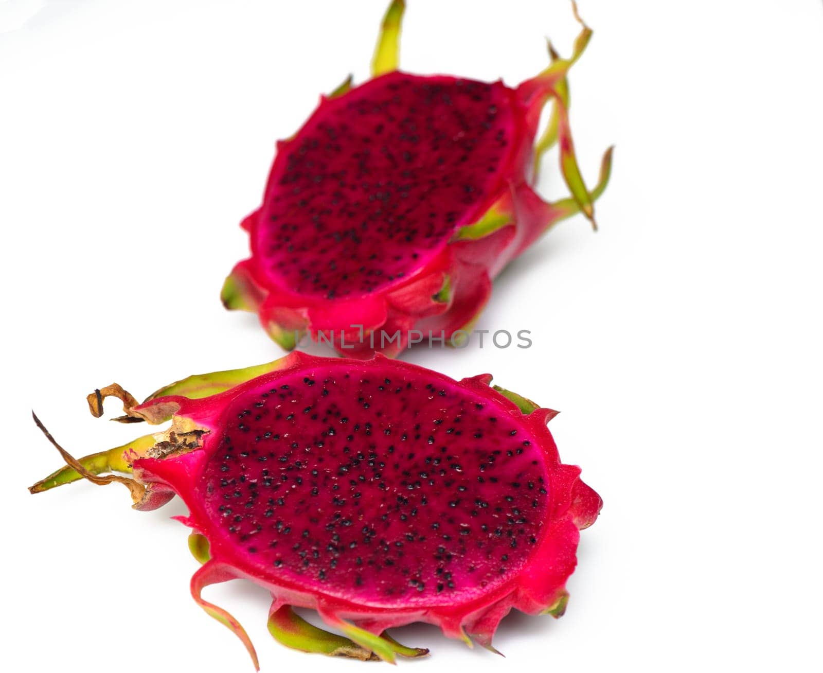 Close up of whole and halved Dragon Fruit or Pitahaya/Pitaya on pale pink background by Mixa74