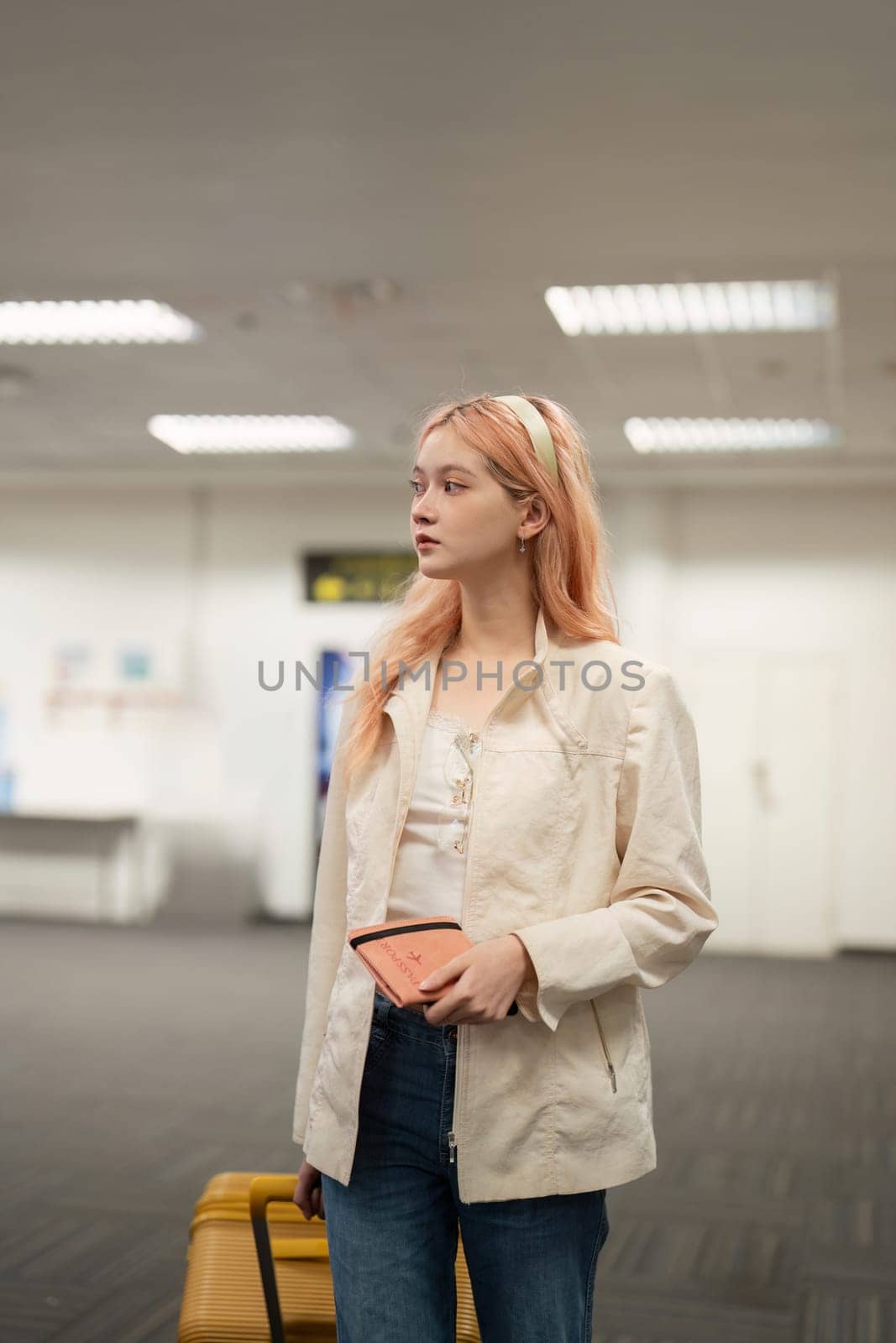 A young woman with luggage at an airport, ready for travel. She embodies modern, independent travel.