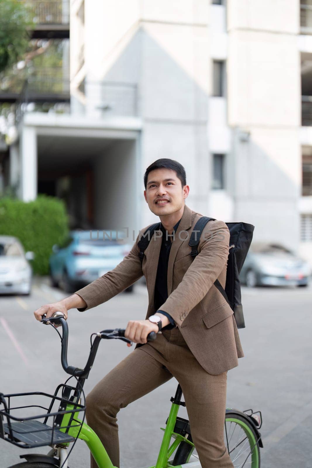 Businessman in a suit riding a bicycle to work, showcasing eco-friendly and sustainable urban commuting, promoting a green lifestyle.