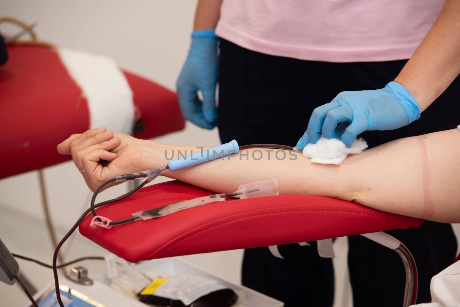 Laboratory and blood analysis concept. Close up cropped shot of professional nurse in gloves, taking a blood sample from arm vein of young female patient by Ashtray25