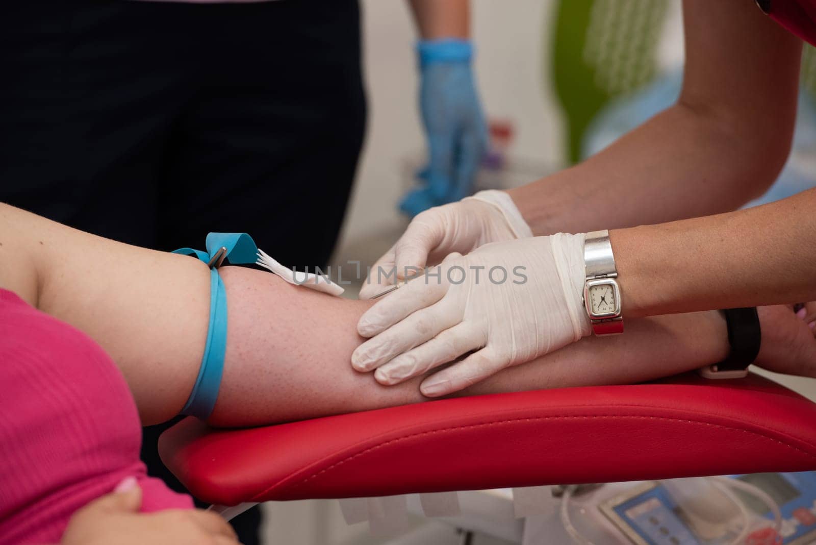 Laboratory and blood analysis concept. Close up cropped shot of professional nurse in gloves, taking a blood sample from arm vein of young female patient by Ashtray25