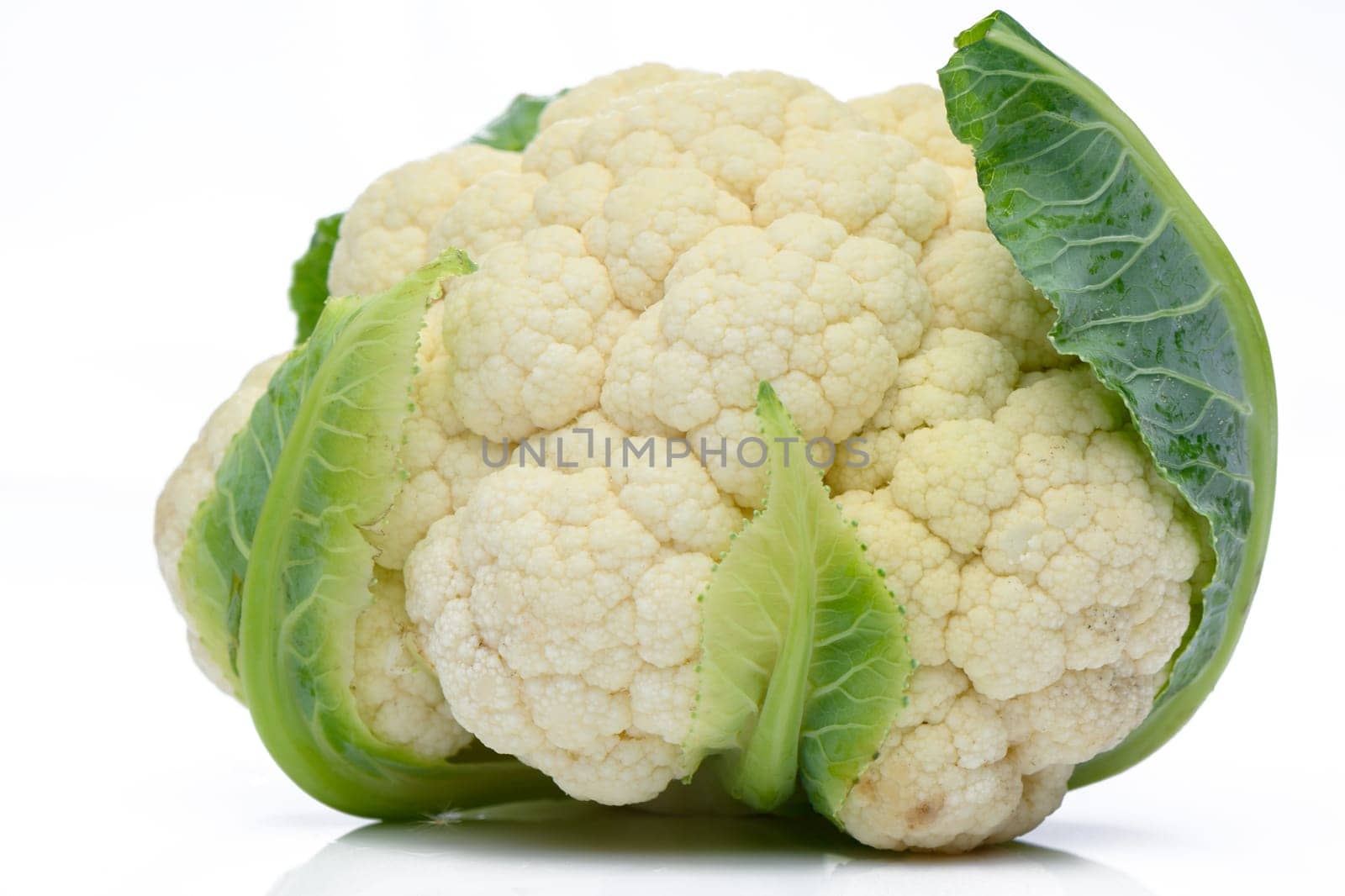 Whole head of the fresh raw cauliflower with some leaves close-up on a white background 2