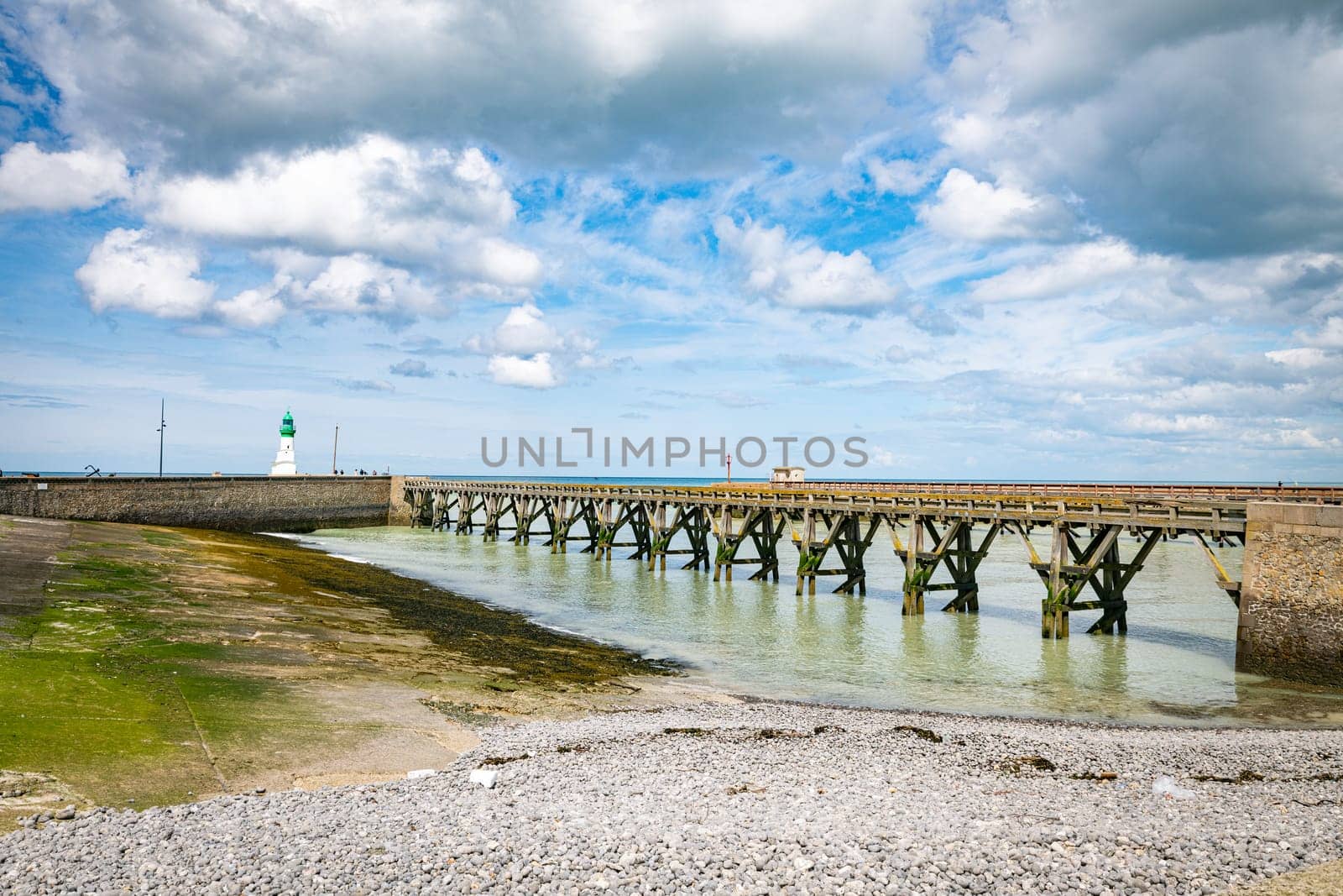 old wooden bridge and lighthouse in the harbor of the french vilage of treport in Normandy