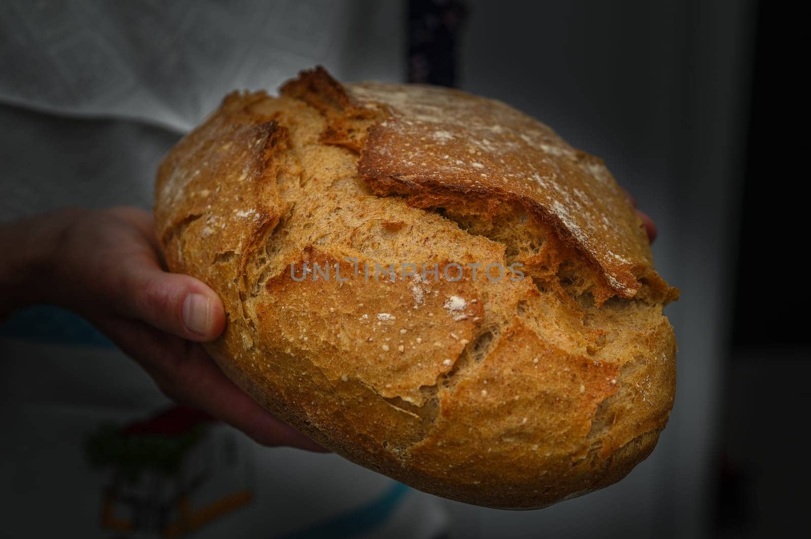 Woman with fresh baked sourdough bread in kitchen by Mixa74