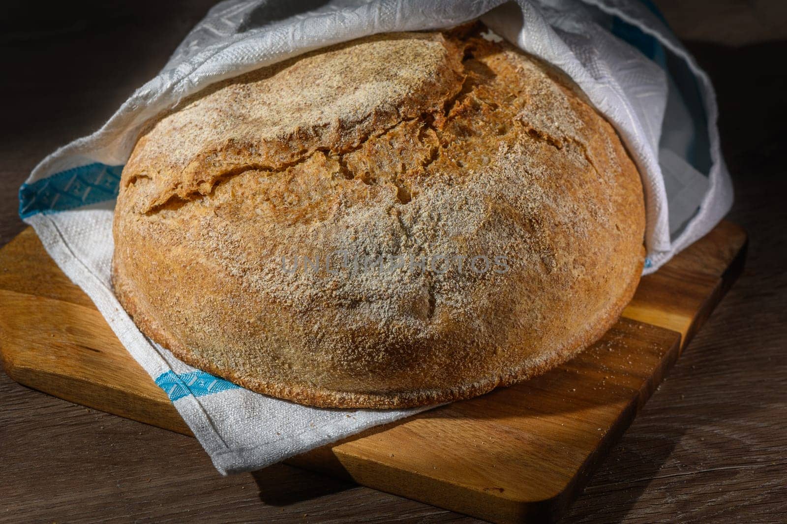 a loaf of freshly baked sourdough bread on a wooden table, 1