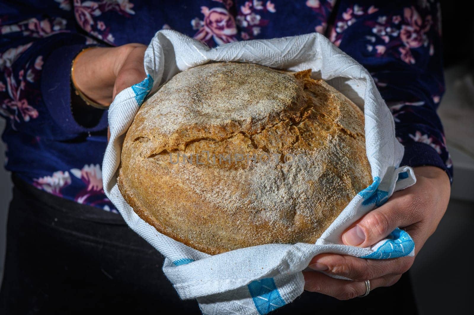 Woman holding freshly baked bread on black background, closeup by Mixa74