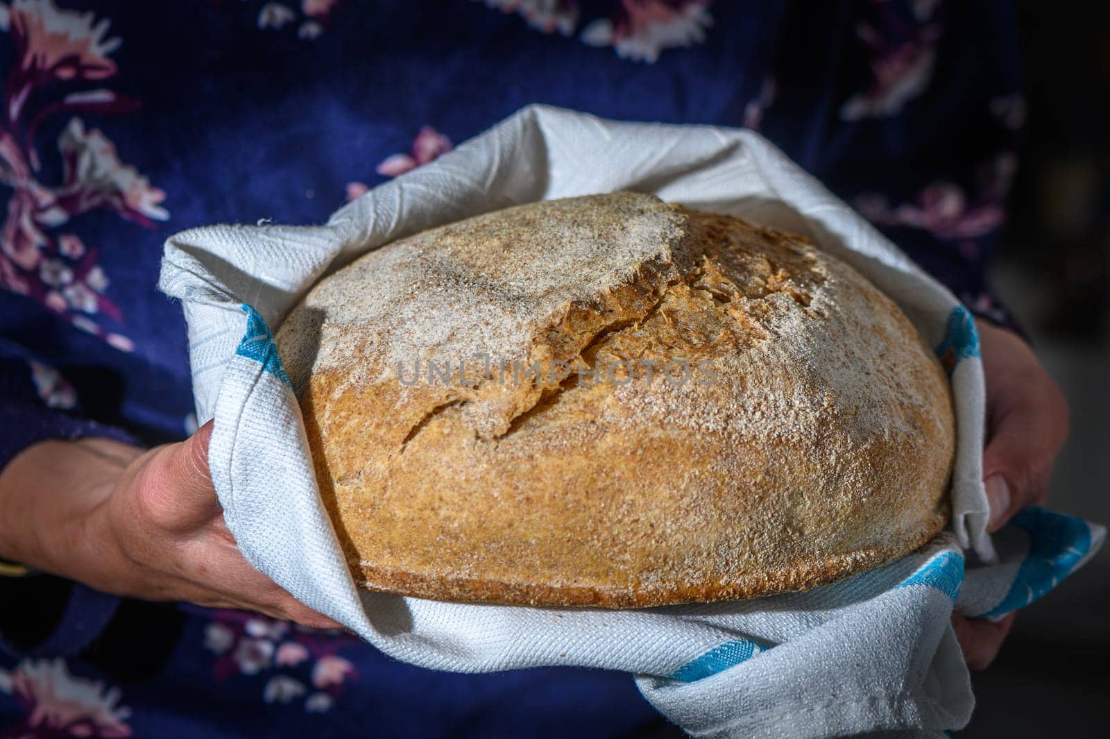 Woman holding freshly baked bread on black background, closeup 1 by Mixa74