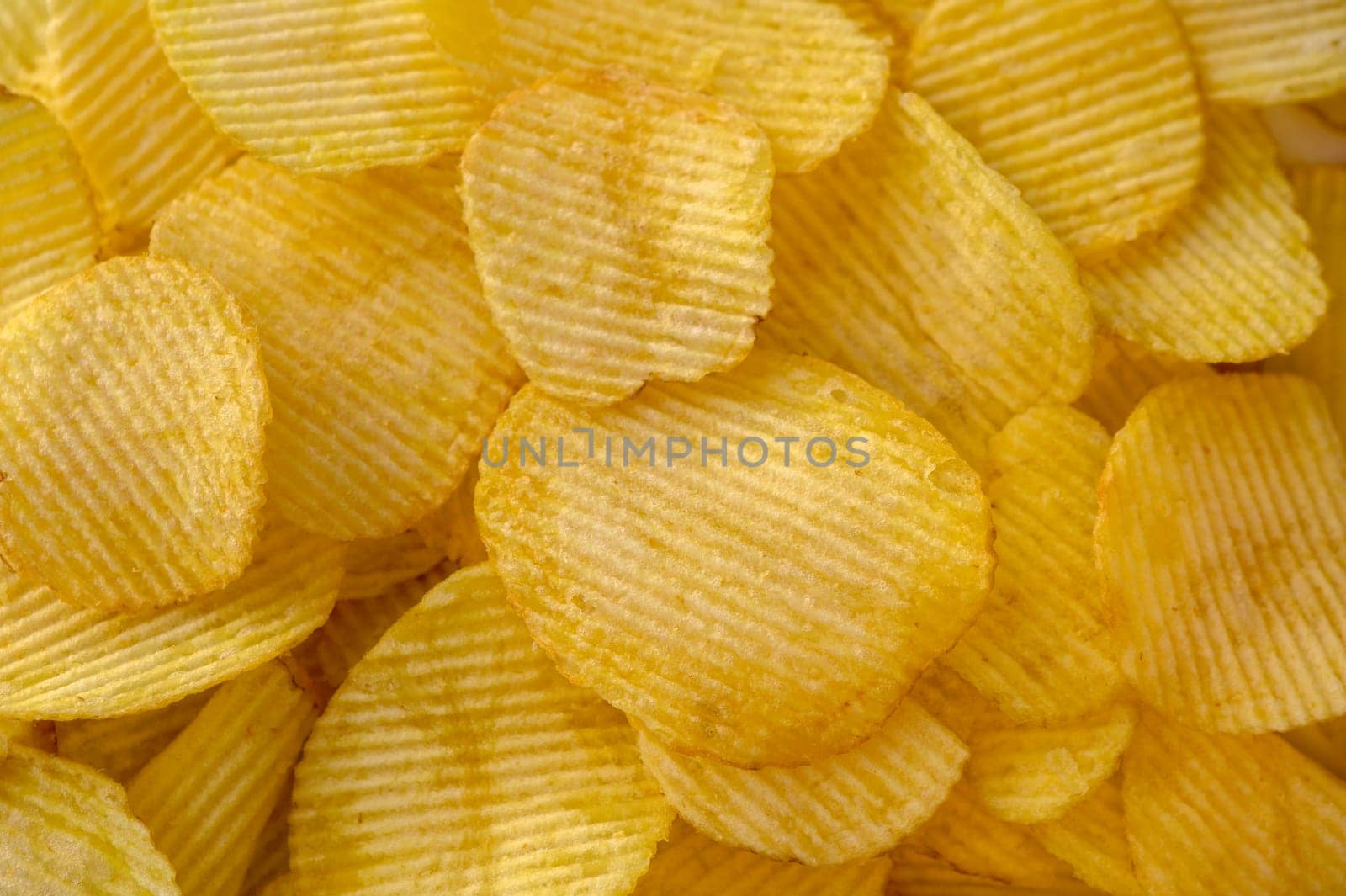 Close-up view of abundant crispy potato chips filling the frame for a textured background 1 by Mixa74