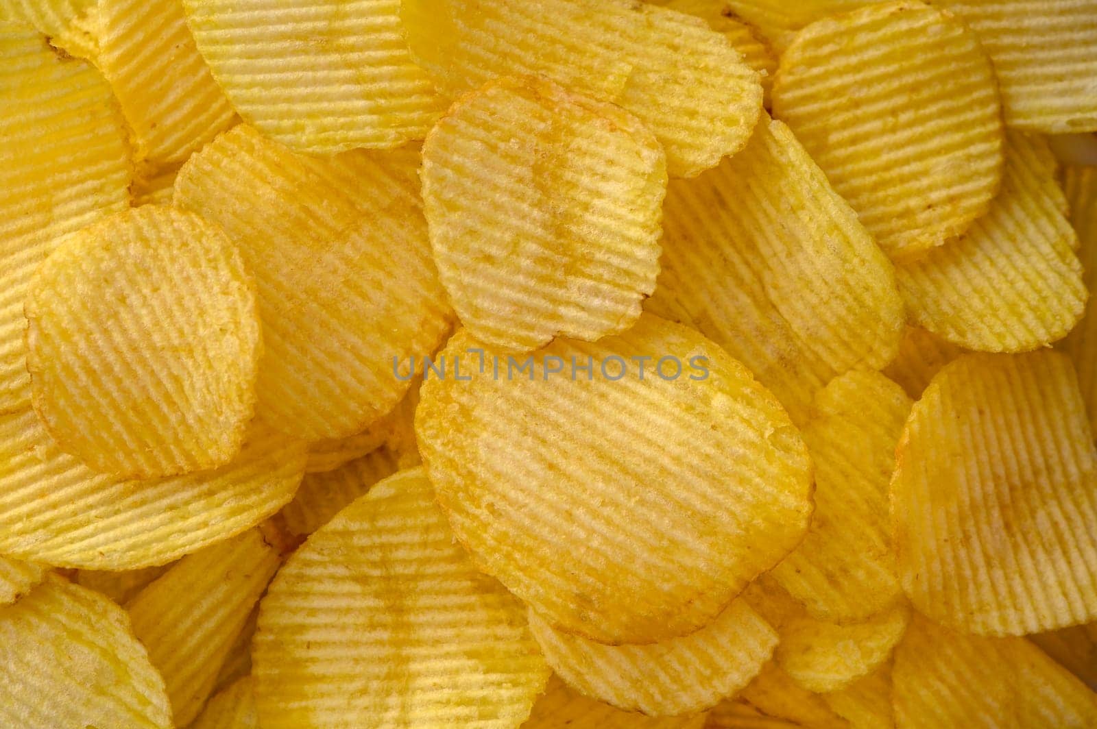 Close-up view of abundant crispy potato chips filling the frame for a textured background by Mixa74