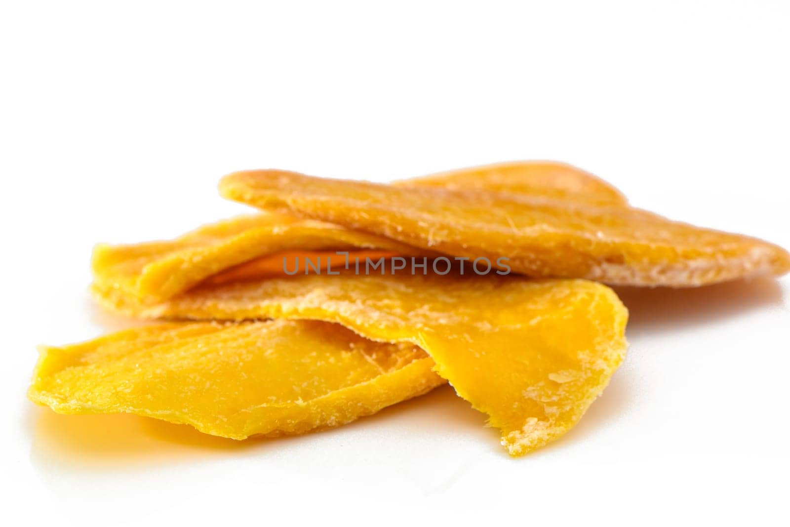 colorful pieces of dried mango fruit on a white background by Mixa74