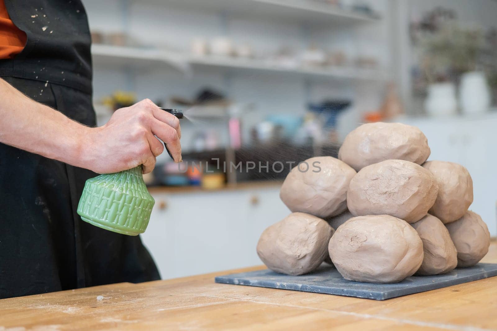 The potter wets the clay before using it in the workshop