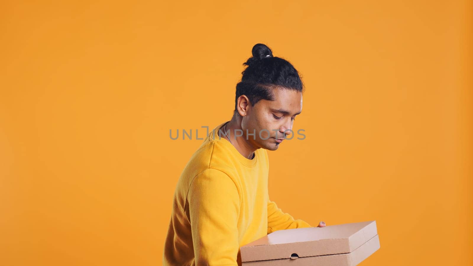 Portrait of man holding thermal backpack, crossing arms, ready to fulfill orders, studio backdrop. Calm food delivery service worker prepared to do delivery to customers, camera B