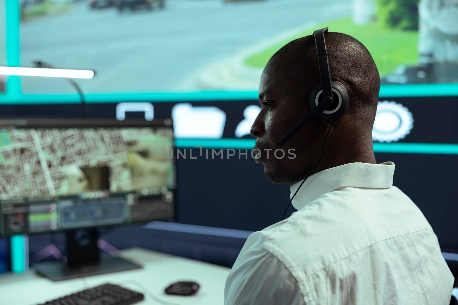 African american guy supervising traffic activity via CCTV system, using surveillance footage and radar in the city. Control center employee tracking cars through security cameras.